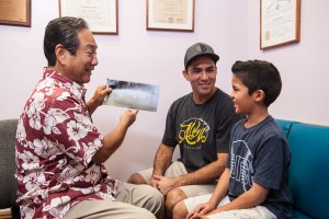 Dr. Dean Sueda consulting with father and son